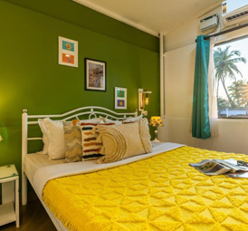 Bedroom with green wall and yellow bedspread