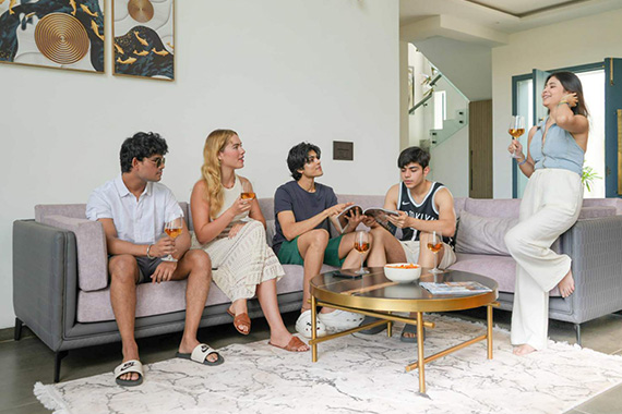 Group of friends relaxing and chatting in the spacious villa living room