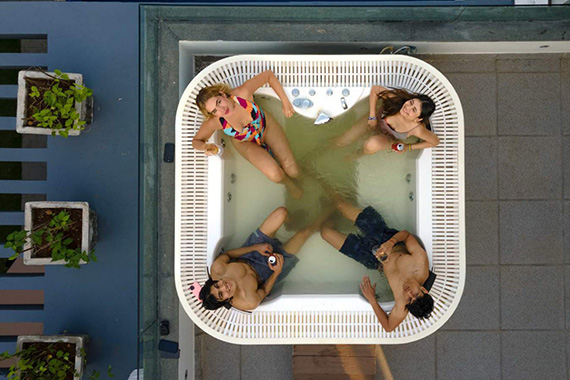 Group relaxing together in the villa’s rooftop hot tub with drinks