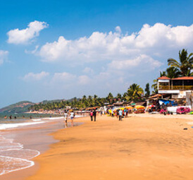 Sunny beach with golden sand, visitors, and lively beach shacks