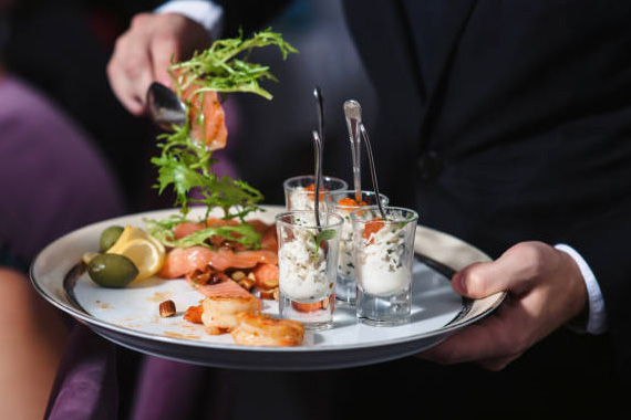 Gourmet appetizers served on a tray by a professional butler