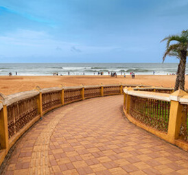 Curved walkway leading to a quiet sandy beach with gentle wave