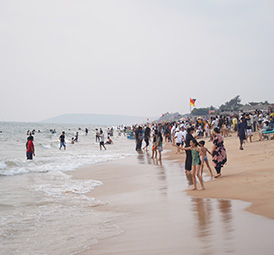 Tourists enjoying Candolim Beach shoreline Goa