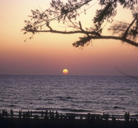 Beautiful sunset view over the sea with silhouettes of people watching