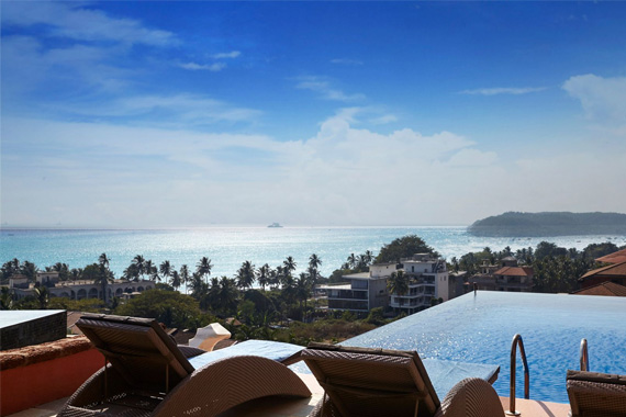 Infinity pool overlooking ocean views with lounge chairs