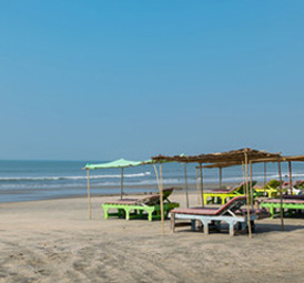 Peaceful beachfront with sunbeds and simple shaded huts