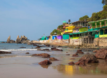 Colorful Arambol Beach shacks by rocky coastline