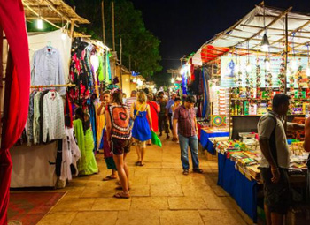 Lively Arpora Night Market with shoppers and stalls