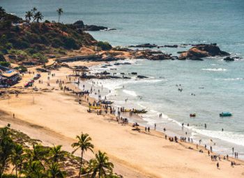 Vagator Beach aerial view with rocky coastline and crowds