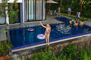 Group relaxing in a poolside setting surrounded by nature