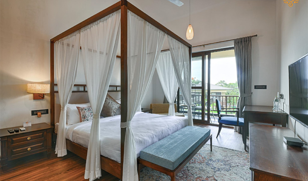 Luxury villa bedroom with canopy bed and balcony in Goa