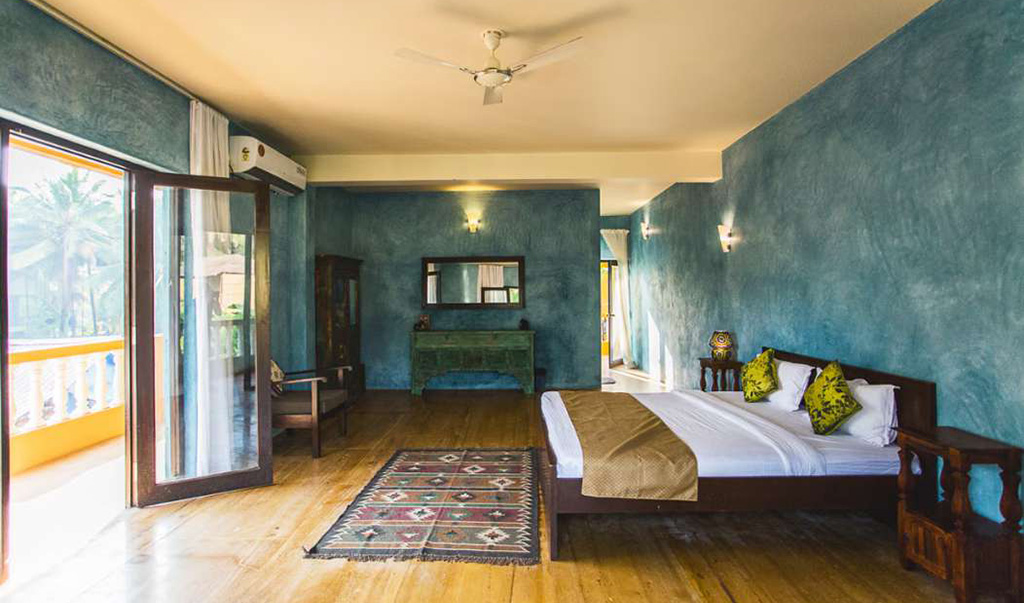 Spacious luxury villa bedroom interior in Goa with balcony and wooden decor