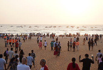 Crowds of visitors enjoying the sandy shoreline and sea view at Calangute Beach in Goa