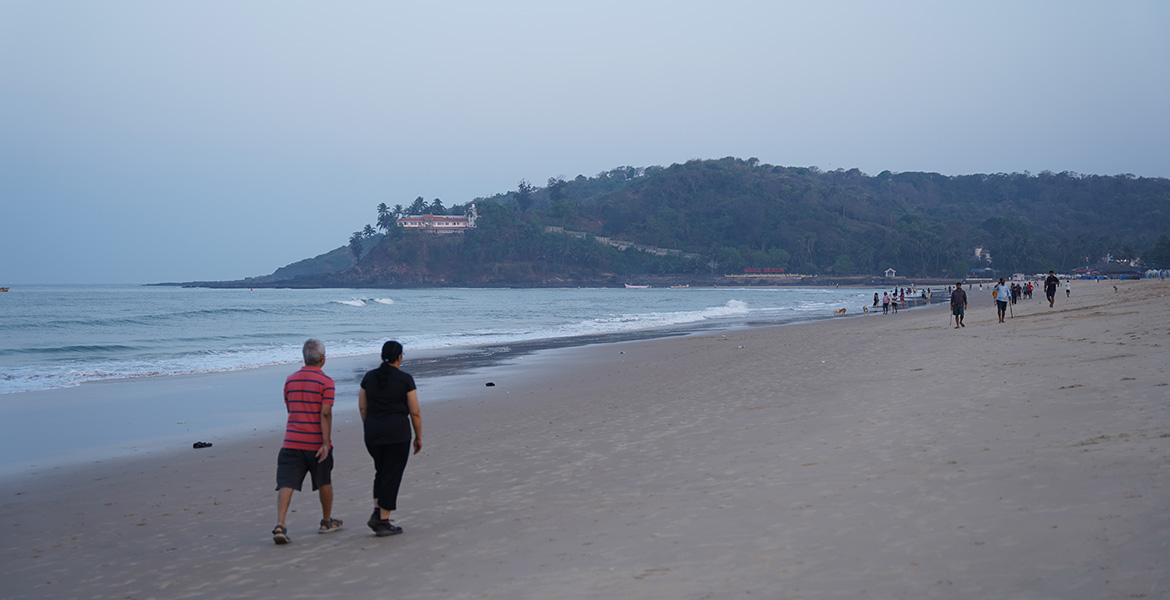 Couple enjoying a peaceful morning walk along Baga Beach in Goa