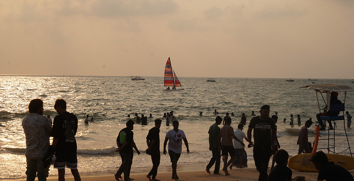 Visitors enjoying the sunset and beach activities at Baga Beach, Goa.