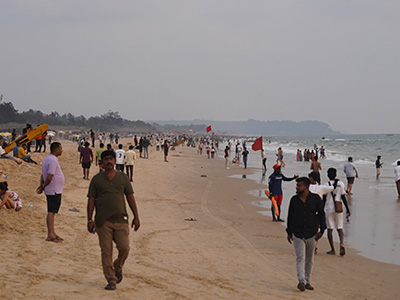 Crowds enjoying an evening stroll along Baga Beach shoreline in Goa