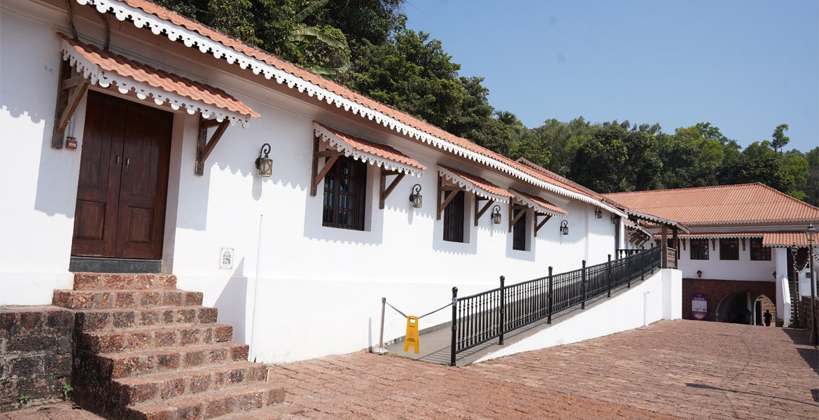 Aguada Jail Museum in Goa with white colonial-style buildings, red tiled roofs, stone steps and a courtyard