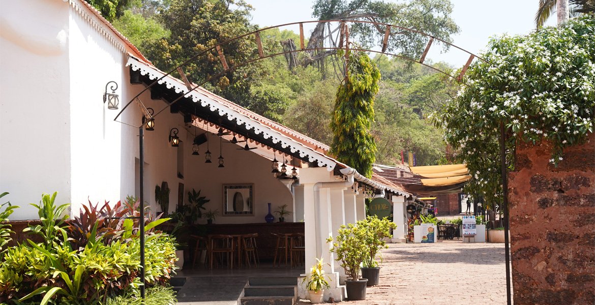 Aguada Jail Museum courtyard with historic white buildings, tiled roofs and greenery in Goa