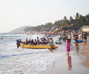 Visitors enjoying banana boat rides and water sports along the sandy shoreline of Anjuna Beach Goa