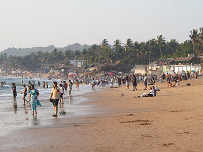 Visitors enjoying the sandy shoreline and lively beach atmosphere at Anjuna Beach Goa