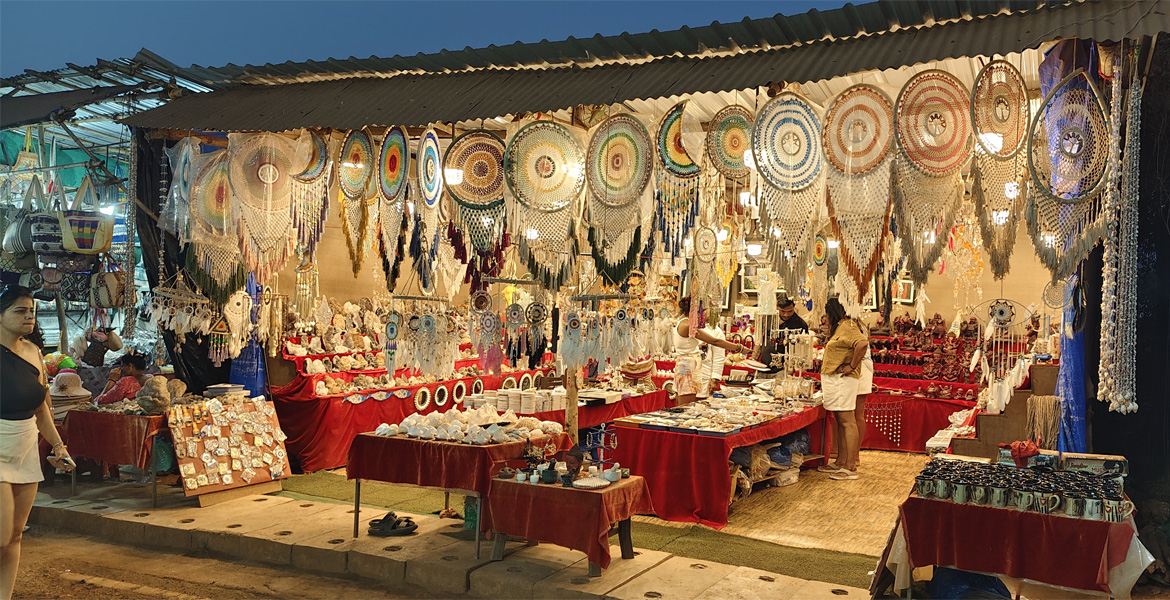 Handicrafts, dreamcatchers, seashell decor, and souvenir stalls at Anjuna Flea Market, a popular shopping destination in Goa
