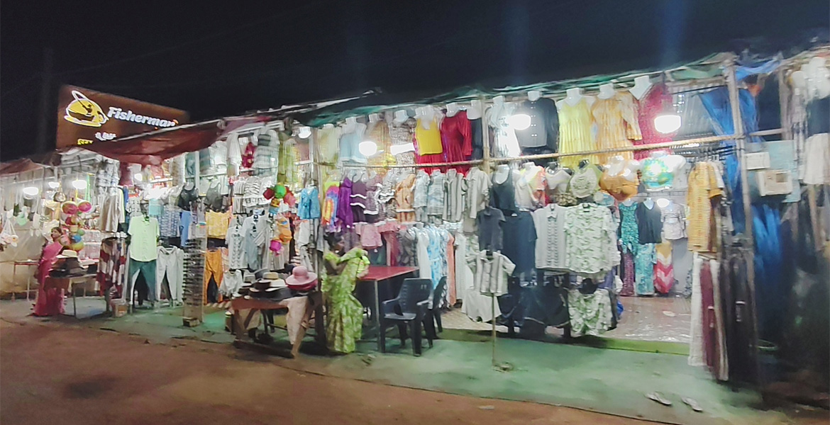 Anjuna Flea Market in Goa at night with clothing stalls