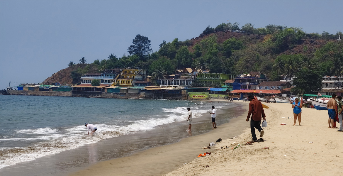 Visitors along the shoreline at Arambol Beach, Goa