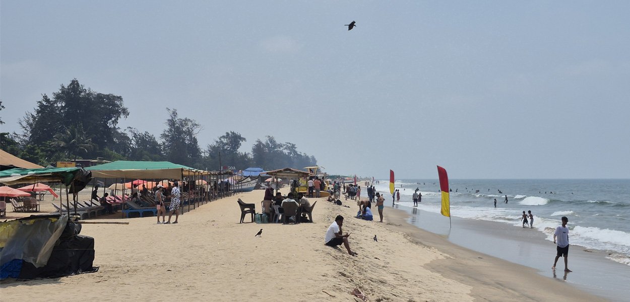 Arambol Beach with beach shacks and flags