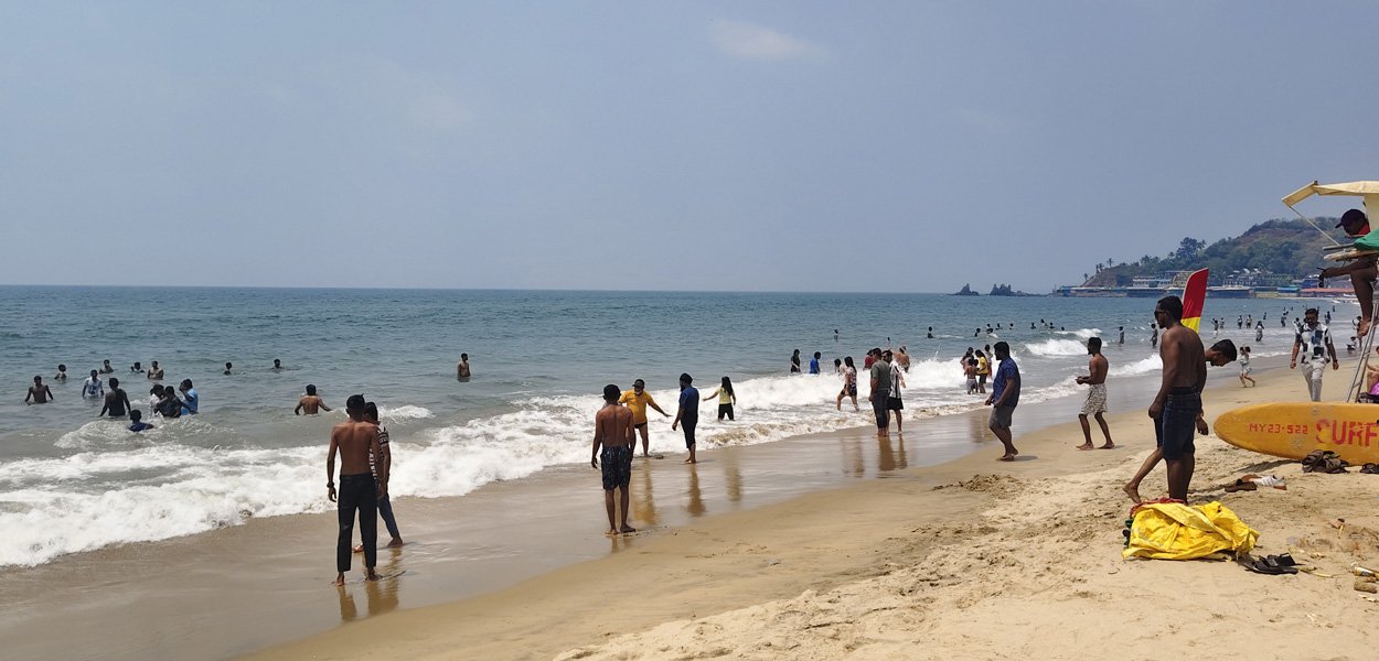 Arambol Beach with swimmers and waves