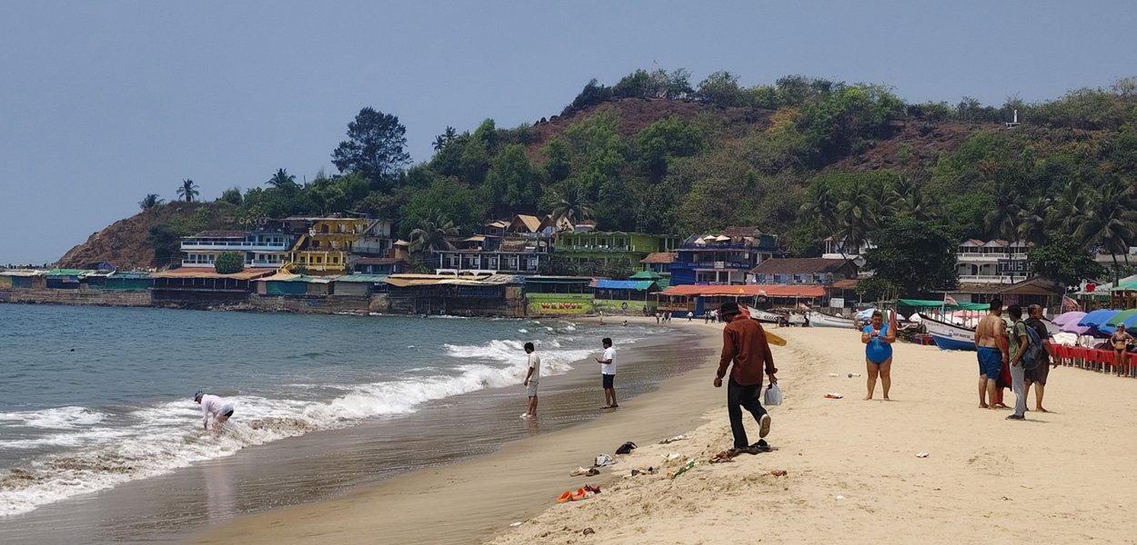 Arambol Beach with seaside village and hill