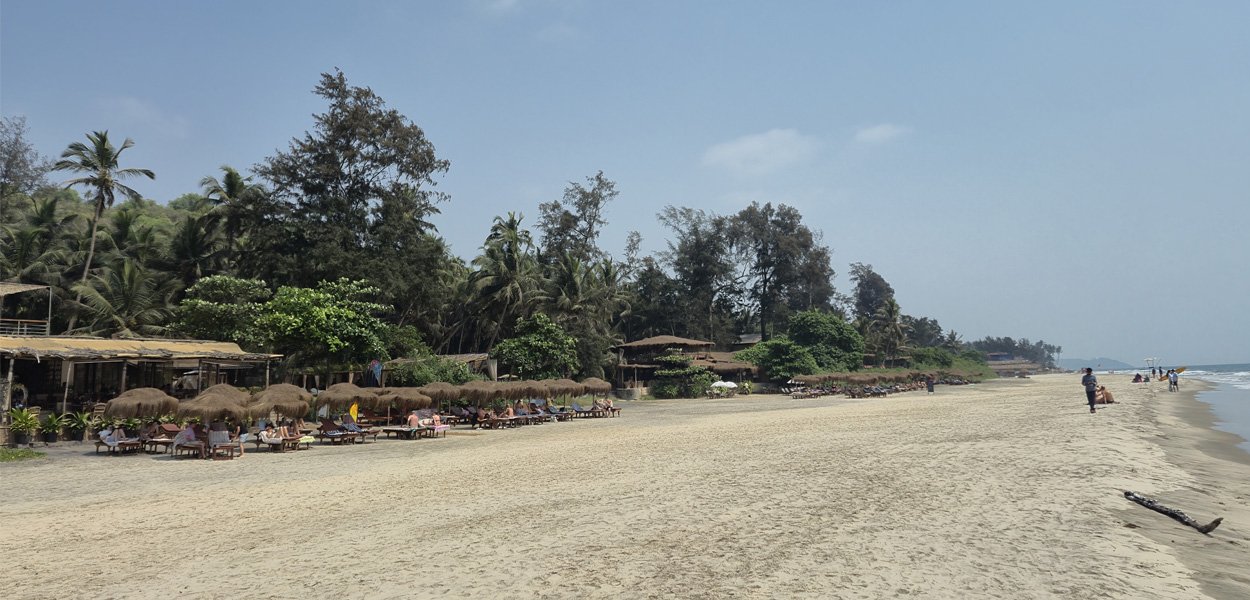 Ashwem Beach Goa with beach huts and palm trees