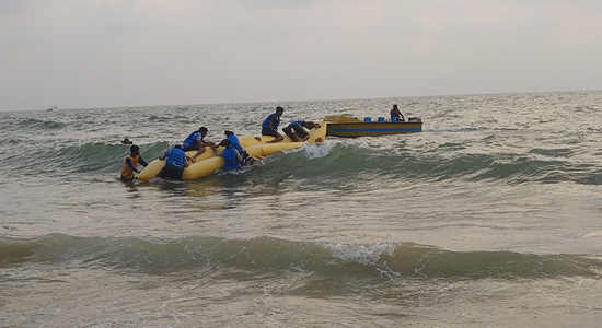People enjoying banana boat water sports activity at Baga Beach in Goa