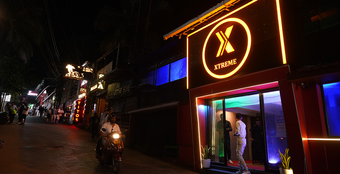 Nightlife street near Baga Food Street in Goa with illuminated clubs and restaurants at night