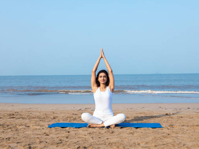 Woman practicing yoga on a beach in Goa