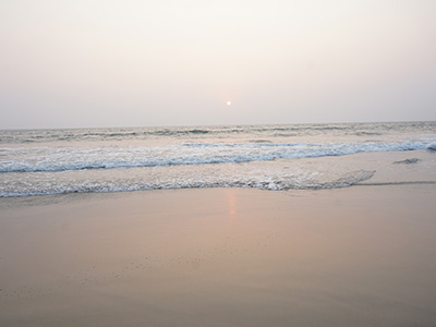 Peaceful sunset over the Arabian Sea at Betalbatim Beach Goa with gentle waves and a sandy shoreline