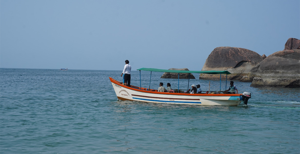 Tourist boat ride near rocky coast in Goa