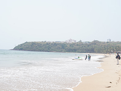 Wide view of the sandy shoreline and calm Arabian Sea waters at Bogmalo Beach Goa