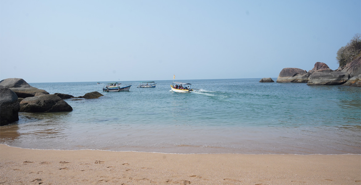 Boats on the clear waters of Butterfly Beach, Goa