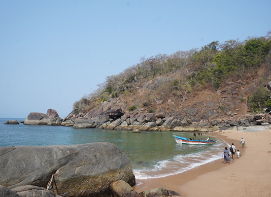 Rocky bay with boat at Butterfly Beach, Goa