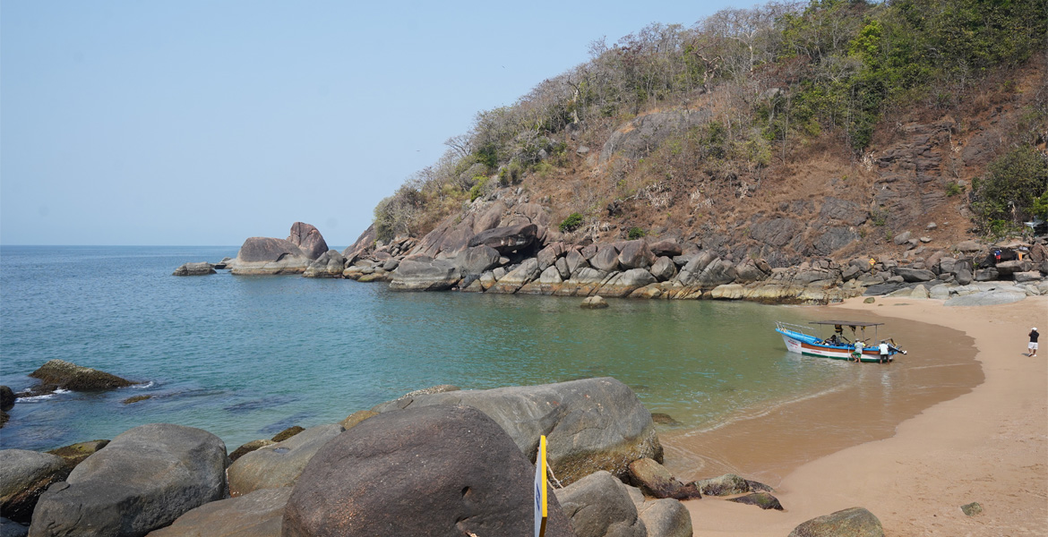 Rocky cove with boat at Butterfly Beach, Goa