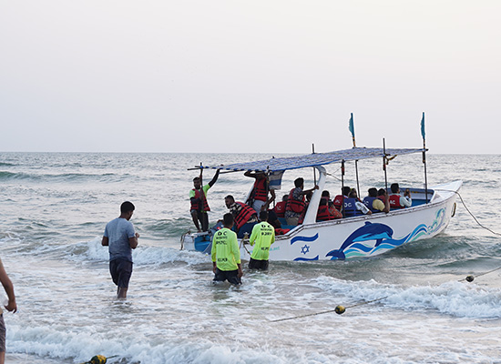 Tourists boarding a boat at Calangute Beach, Goa