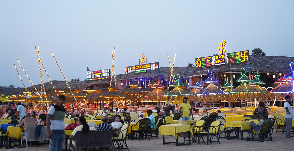 Colorful beach shacks and nightlife setup at Calangute Beach with illuminated seating, restaurants, and evening crowd by the beach