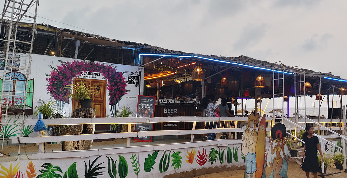 Beachside restaurant and shack with evening lights and seating area near Candolim Beach in Goa