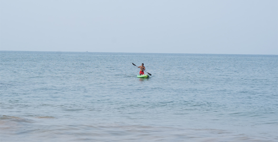 Person kayaking in the calm sea at Cola Beach, Goa