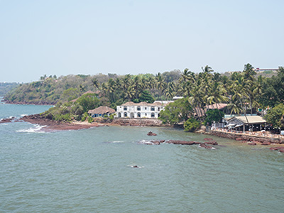 Scenic coastal view from Dona Paula Viewpoint in Goa with palm trees and seaside buildings