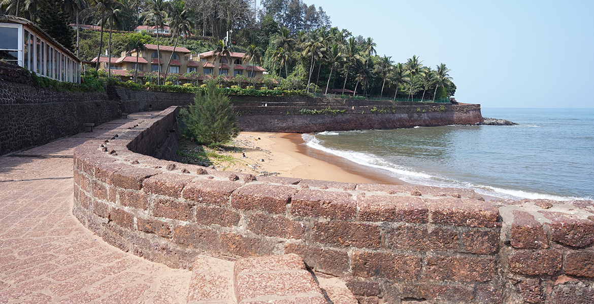 Stone fort walls and coastal view at Fort Aguada in Goa overlooking the beach and Arabian Sea