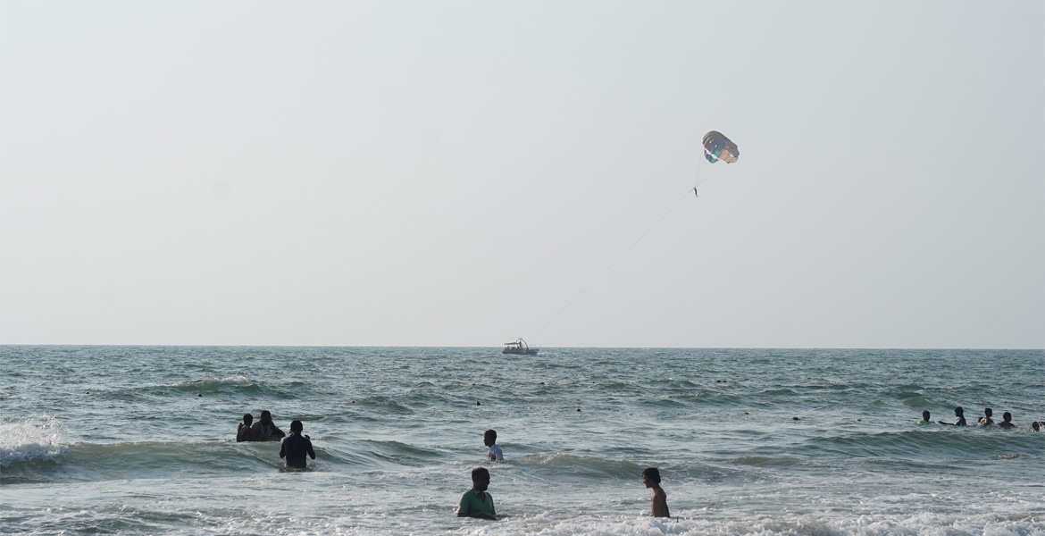 Parasailor above swimmers in Goa