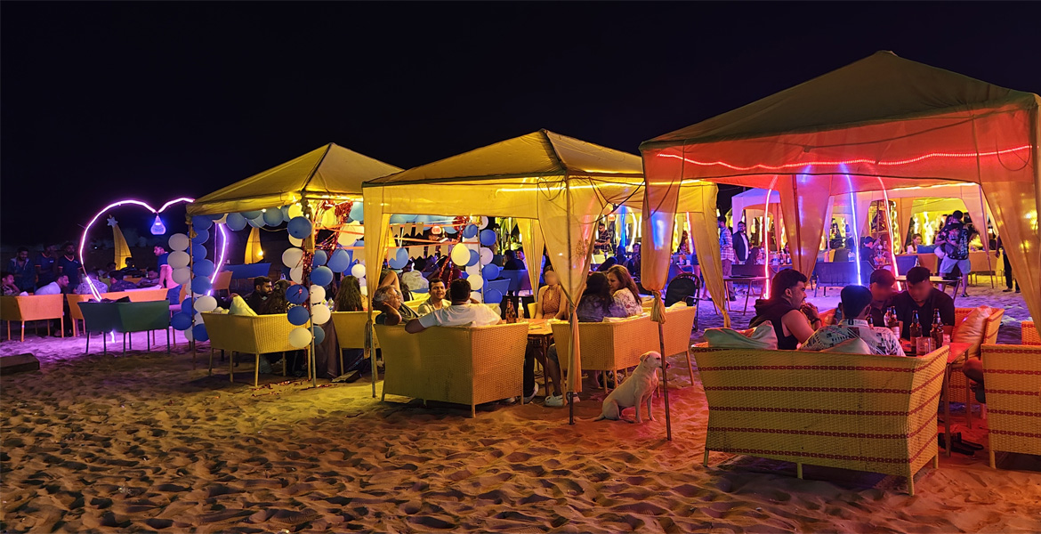 Beachfront bars in Goa with outdoor seating and colorful lights at night