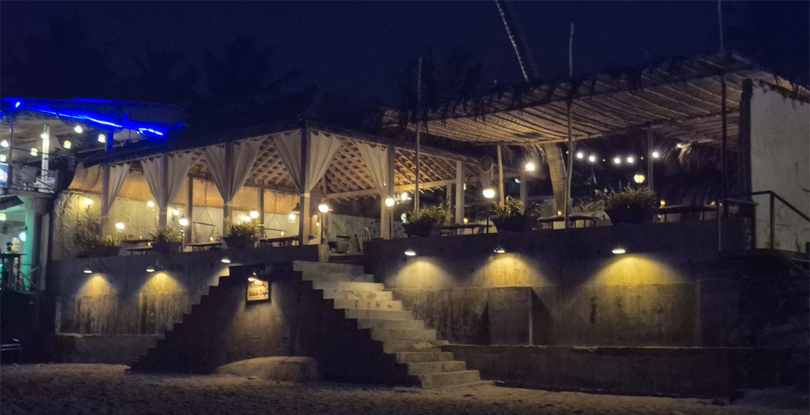 Beachside restaurant in Goa at night with outdoor seating and warm lights
