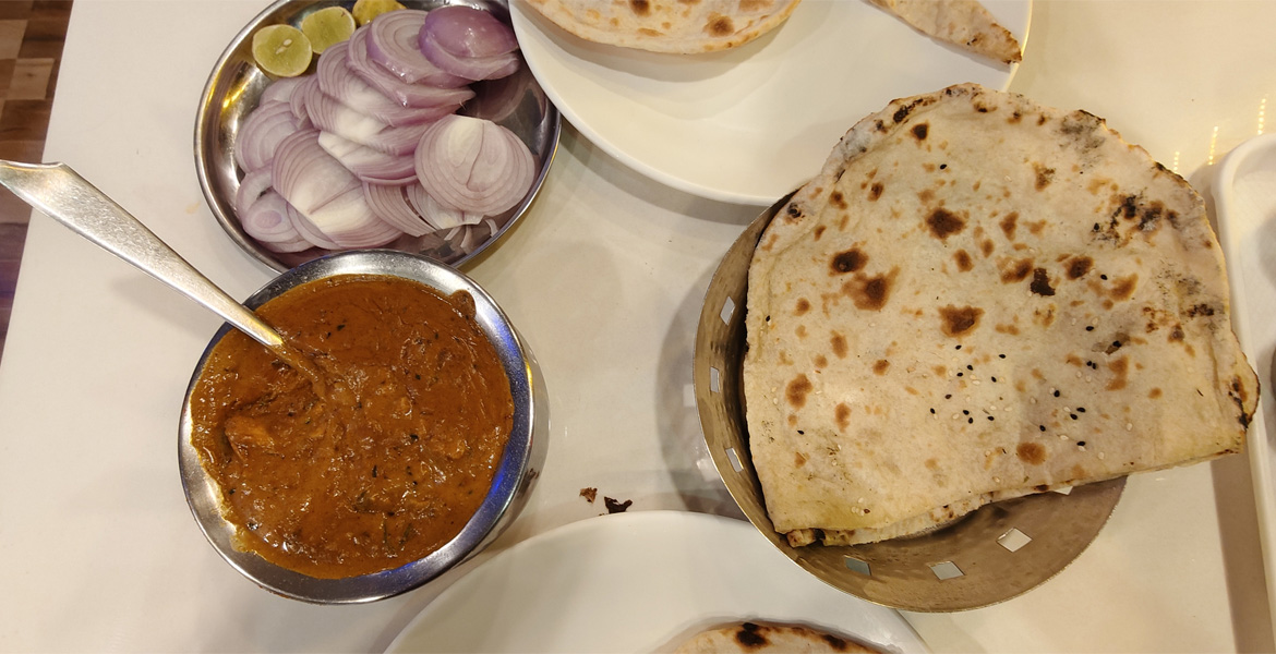 Goan naan served with chicken curry and sliced onions